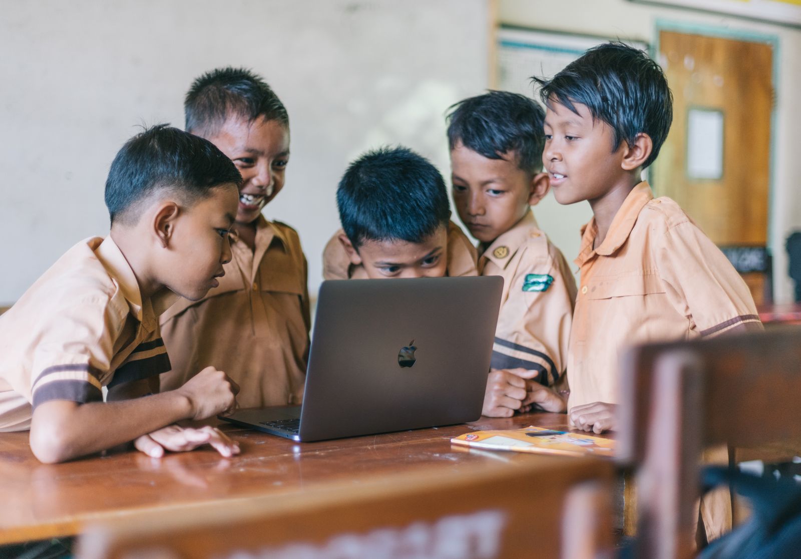 Primary school students learning together on a laptop in a digital literacy programme